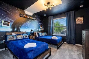 Un dormitorio con temática de Star Wars, con dos camas, un mural y un cartel de 'Se busca'.