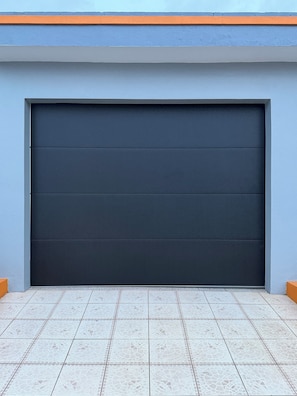 A garage door with a dark color and a tiled floor.