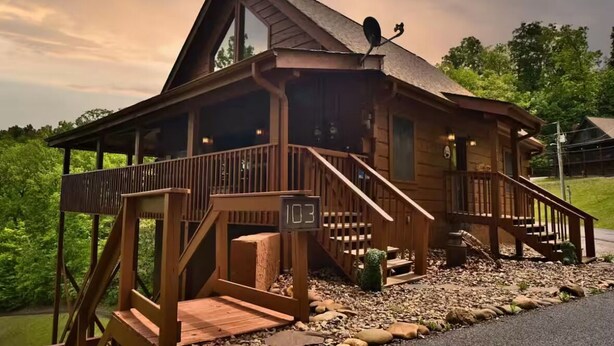 A wooden cabin with a porch, a staircase, and a satellite dish. -  Washer dryer arcade game hot tub Waterview 3 bedroom 4 bed Awesome cabin.  (Sevierville)