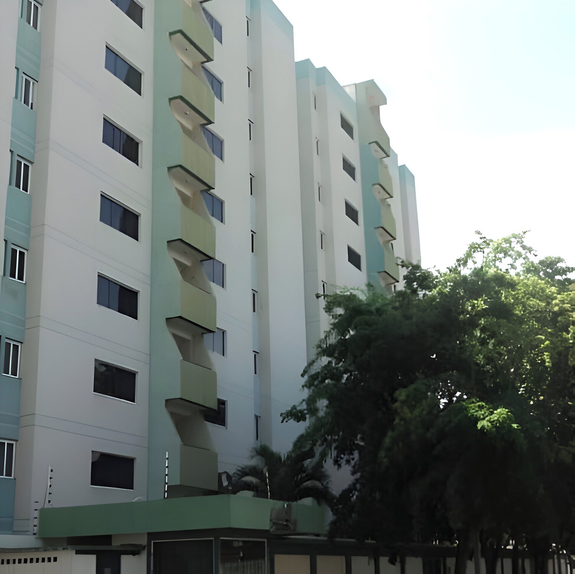 Un immeuble à plusieurs étages doté d’une architecture moderne, avec des balcons et une série de fenêtres.