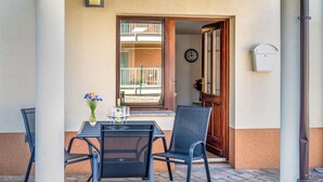 An outdoor patio with a table and chairs, a clock on the wall, and a mailbox. - Adelsberg Inn by Interhome (Postojna)