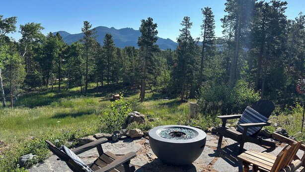 An outdoor seating area with Adirondack chairs and a fire pit, surrounded by a forest and mountains in the background. - The Outlook-Golden Gate Canyon, Black Hawk
3BR/2BA mountain home sleeps 6 guests (Black Hawk)