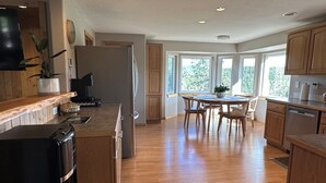 A spacious kitchen with wooden cabinets, a black refrigerator, and a dining area with a table and chairs. - The Outlook-Golden Gate Canyon, Black Hawk
3BR/2BA mountain home sleeps 6 guests (Black Hawk)