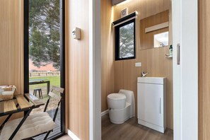 A compact bathroom with a toilet, sink, and mirror.