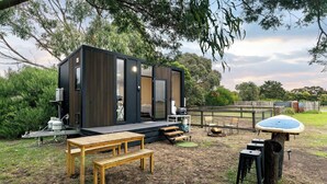 Una estructura moderna al aire libre con un escenario, asientos y una zona de parrilla.