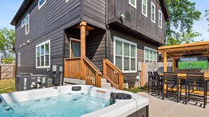 A house with a hot tub, outdoor seating, and a TV screen. - CP ~ Hot Tub ~ Outdoor Lounge & TV ~ Walkable to Local Food & Drinks ~ Free Parking ~ Sleeps 10 (Nashville)