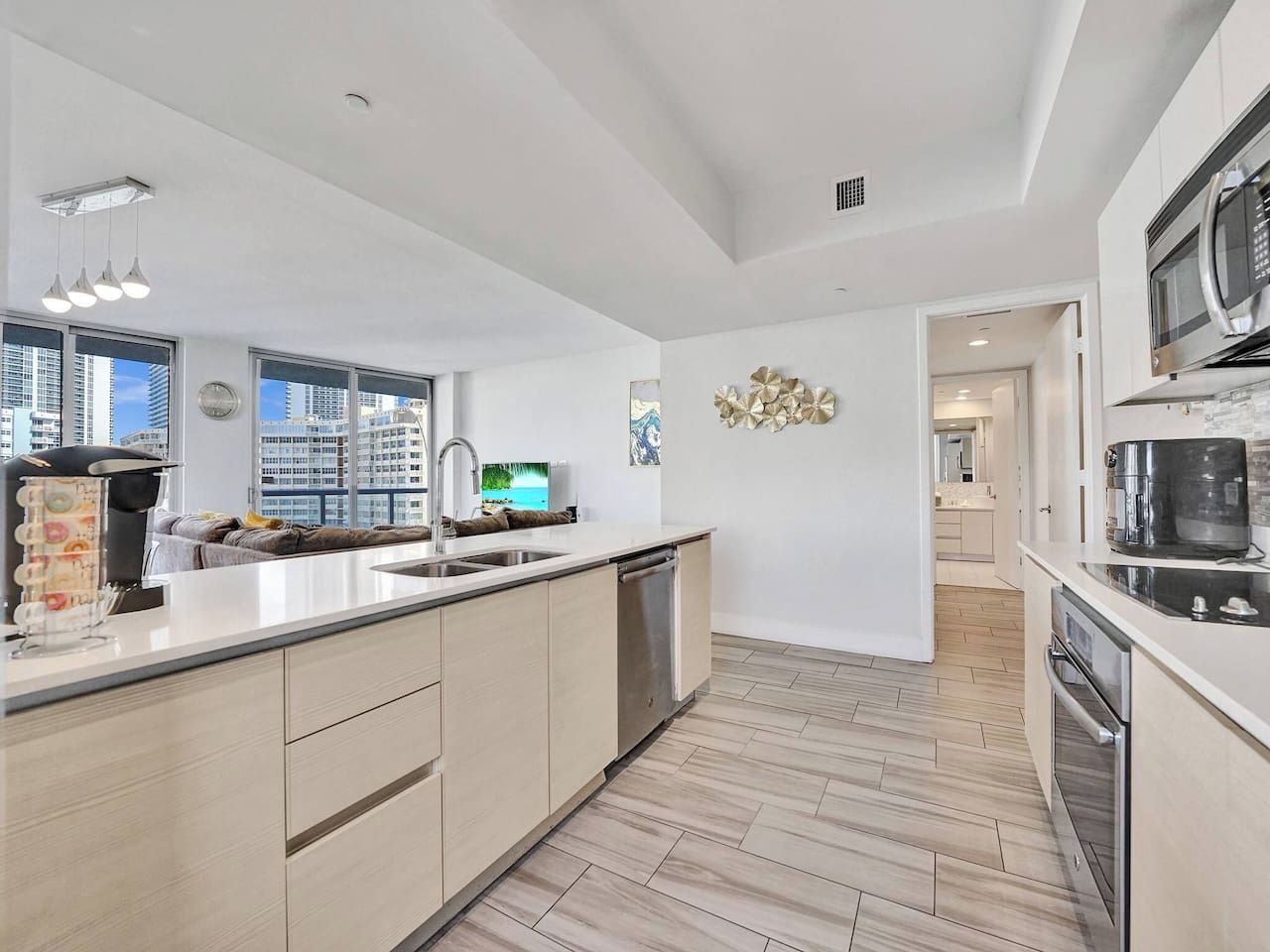 A modern kitchen with a central island, stainless steel appliances, and a view of the city.