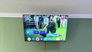 Un televisore fissato a parete con un mobile in legno sottostante.