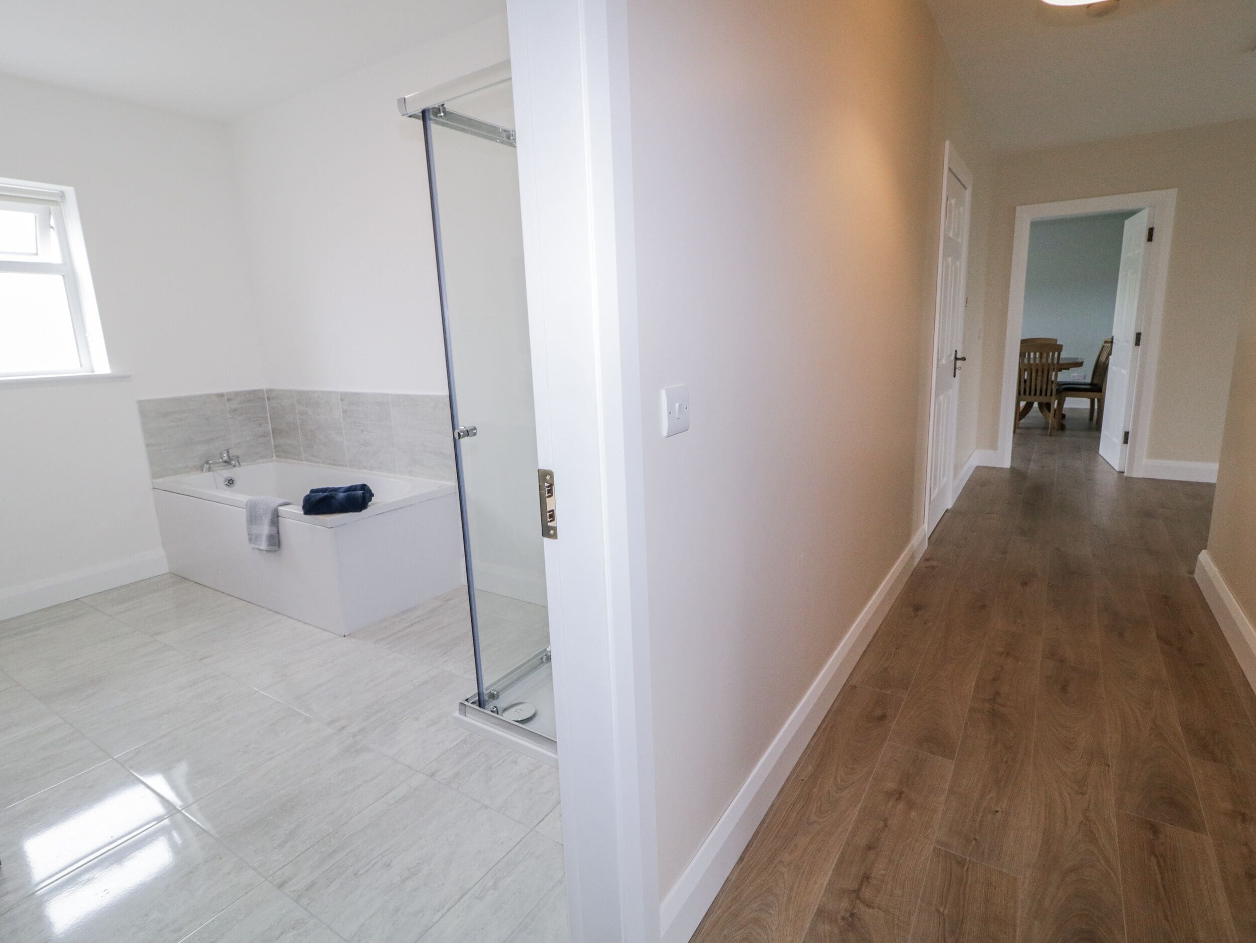 A modern bathroom with a bathtub, a glass shower enclosure, and a walk-in shower.