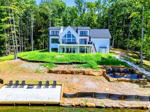A modern two-story house with a large deck, surrounded by a forest. - Lakefront Lake Anna, Beach, Dock, Views (Bumpass)
