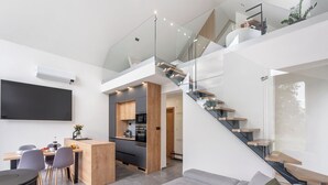 Een moderne woonruimte met keuken, eethoek en een trap.