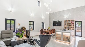En rummelig opholdsstue med pejs, moderne møbler og et køkken med et fjernsyn.