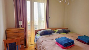 A bedroom with a bed, a wooden dresser, a chair, and a chandelier. - Bright house with garden, balcony, panoramic view and fully equipped kitchen. (Pilisvörösvár)