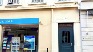 Ein Schaufenster mit einem blauen Schild, auf dem "VOYAGES" steht, und einem großen Plakat, das "MERVEILLES DE EUROPE" bewirbt.
