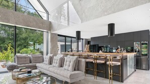 A modern kitchen with a central island, stainless steel appliances, and a bar area.