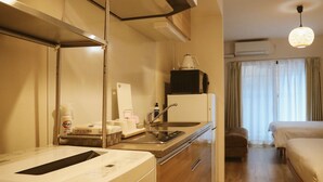 Quarto de hotel com cozinha compacta, uma cama, banheiro e vista para o exterior.