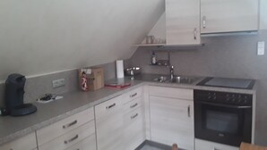 A kitchen with white cabinets, a black stove, and a sink.