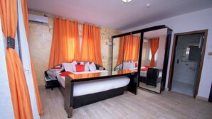 A bedroom with a bed, a desk, and a mirror. - Saint David Hôtel Résidence (Douala)