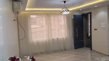 Ein modernes Zimmer mit Holzboden, einer Deckenleuchte und einer Tür.