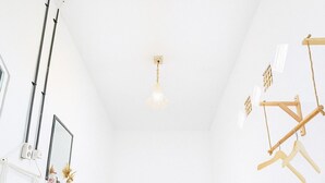 Un dormitorio con cama, lámpara colgante y estante en la pared.