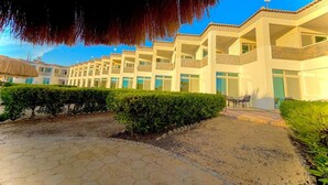 Un hotel con diversi piani, posti a sedere all'aperto e cielo sereno.