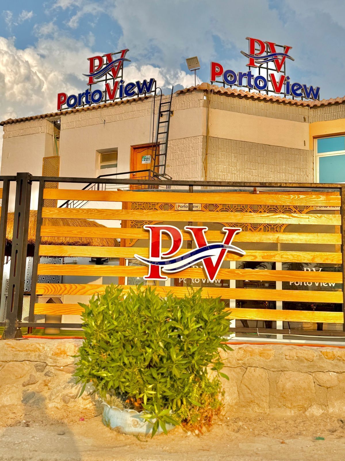 A hotel entrance with a wooden gate displaying the logo 'Porto View' and a sign above the gate.