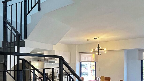 Un interior moderno con una escalera, un comedor y una cocina.