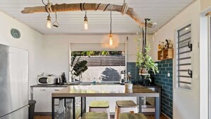 A kitchen with a wooden island, stools, a microwave, and a hanging light fixture. - Private 3BR Villa with pool (Moorea-Maiao)