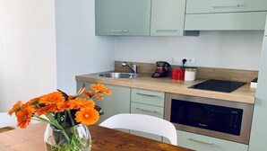 A kitchen with a wooden countertop, a stainless steel sink, a coffee maker, and a microwave.