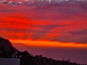 Un atardecer sobre un paisaje montañoso con cielo despejado.