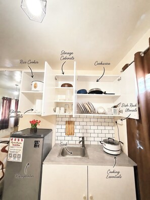 Uma cozinha compacta com geladeira, pia e armários.