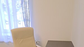 A room with a white office chair and a dark table. - Cool 2-bedroom apartment with AC in Szeged (Szeged)