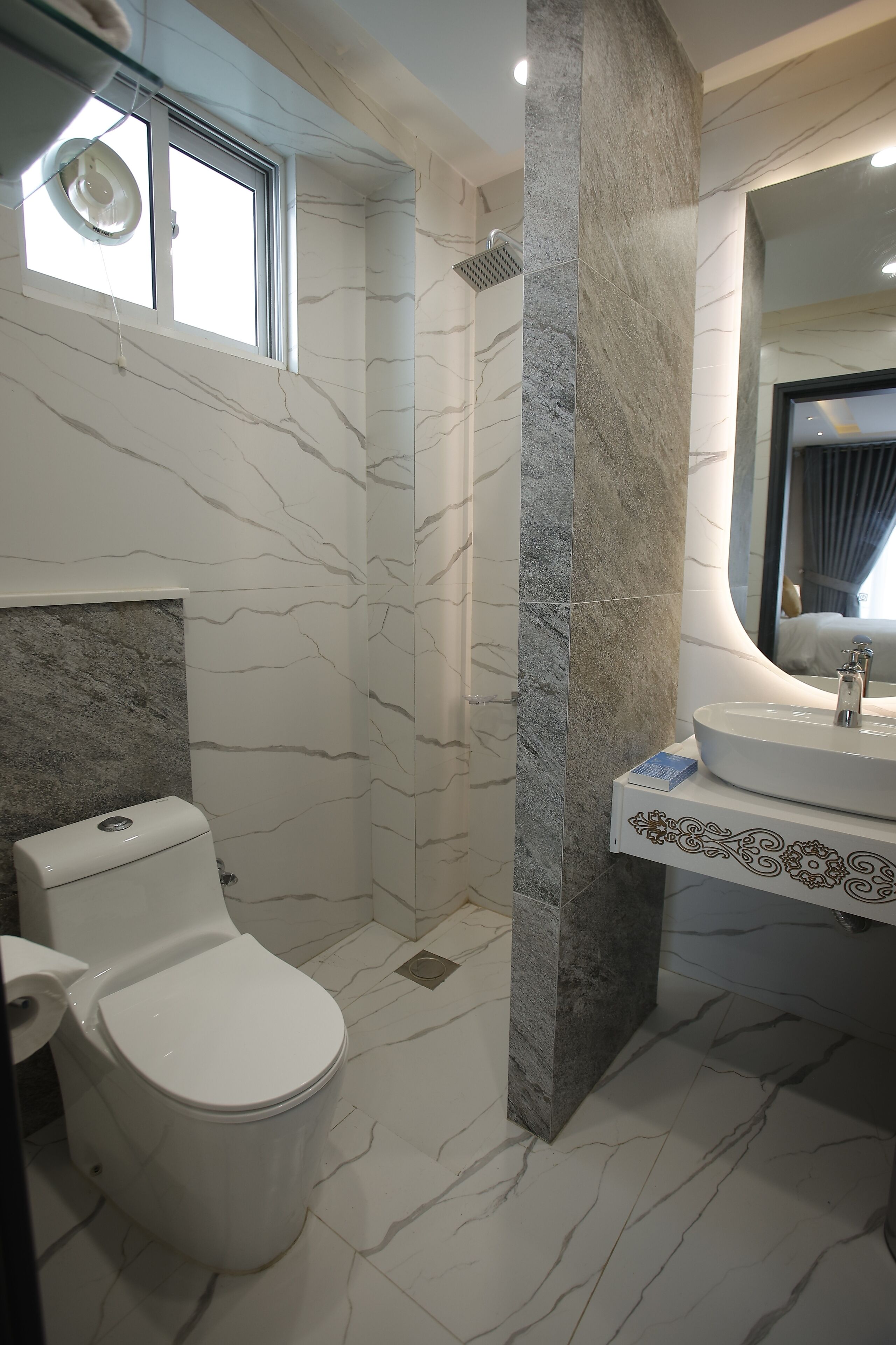 A bathroom with a toilet, sink, and shower.