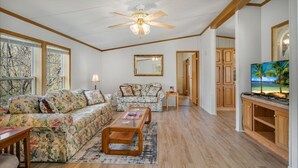 A living room with a sofa, a coffee table, a lamp, and a TV. - Nature-filled escape near Seneca Falls—sleep 8, explore wineries, and unwind in total comfort. (Seneca Falls)