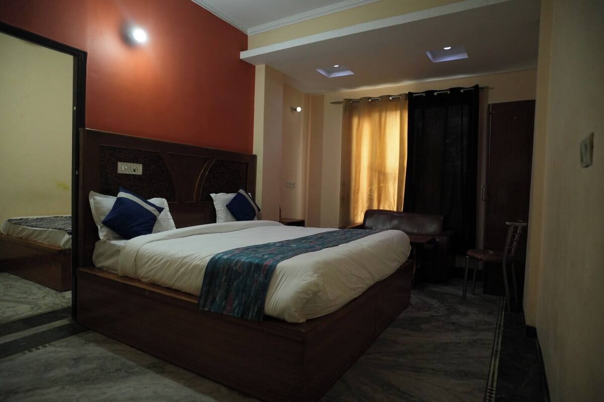 A hotel room with a large bed, a desk, and a chair.