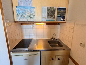 A compact kitchen with a sink, stove, and a dishwasher. Above the counter, there are informational posters. - Studio 3 pers, slopeside with balcony (Les Adrets-Prapoutel)