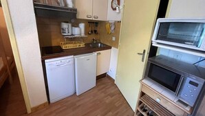 A compact kitchen with a dishwasher, a microwave, and a sink.