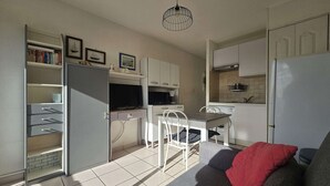 Um espaço compacto com cozinha compacta, área de refeições e sofá.