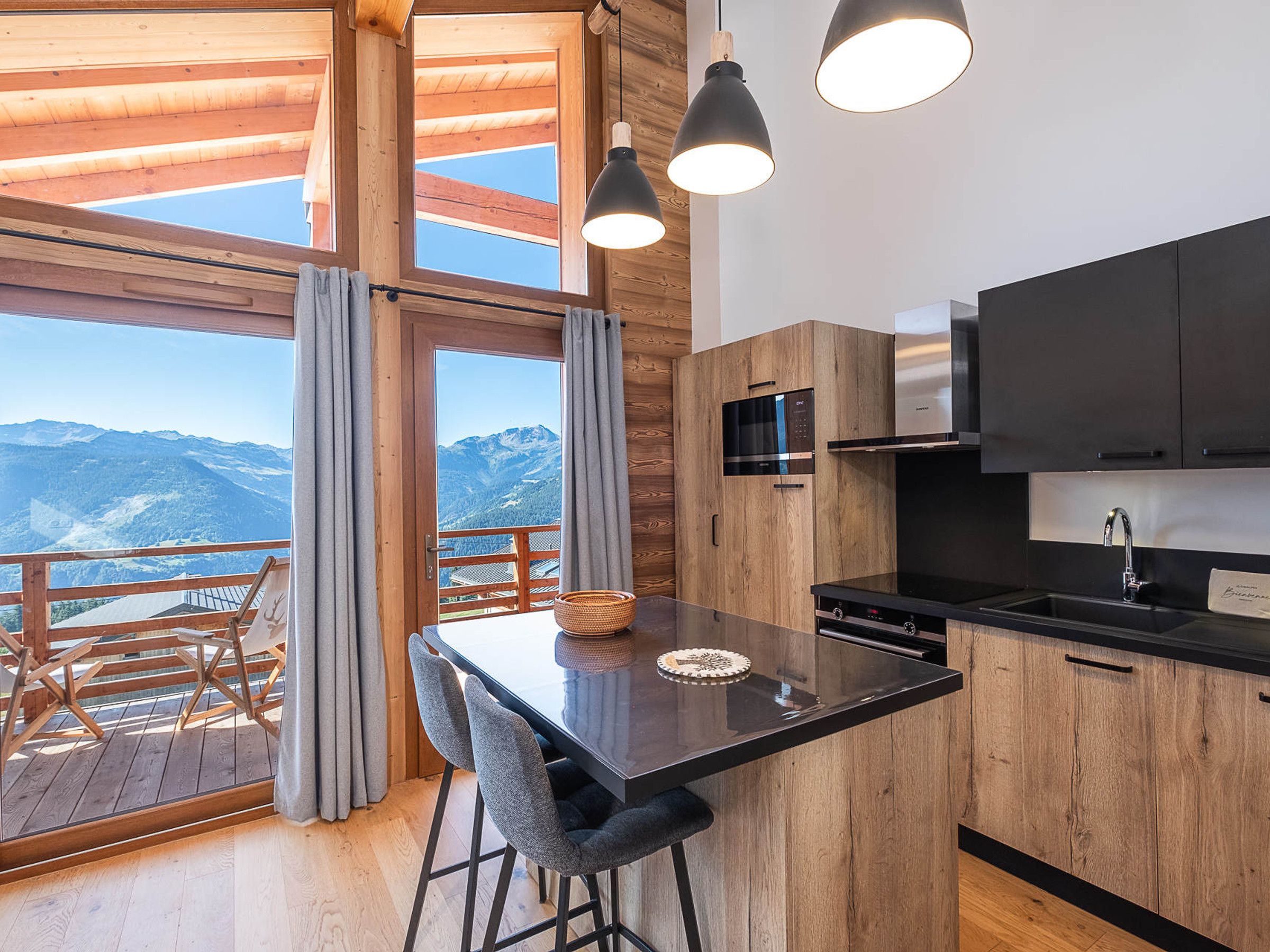 Une cuisine moderne avec des meubles en bois, un plan de travail noir et un four à micro-ondes encastré.