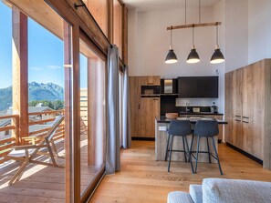 Une cuisine moderne avec des meubles en bois, un îlot central et des luminaires suspendus.