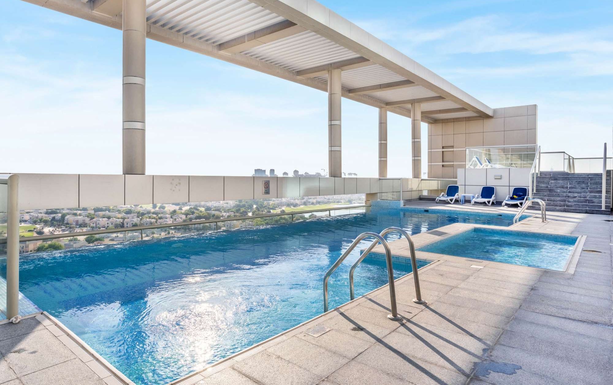 Une piscine extérieure offrant une vue dégagée sur le paysage urbain en arrière-plan.