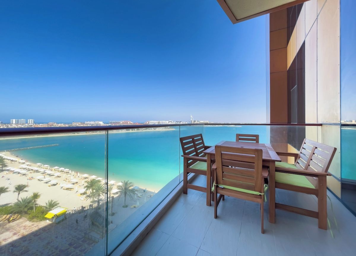 A balcony with a view of a beach and ocean.