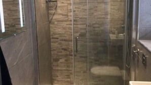 Un bagno moderno con doccia vetrata, un water e un lavandino.