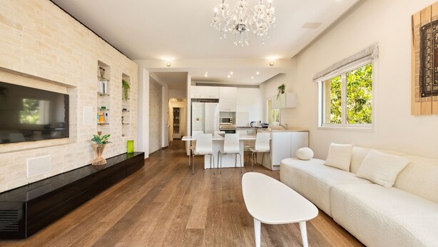 Una sala de estar moderna con chimenea, un comedor y una cocina al fondo.