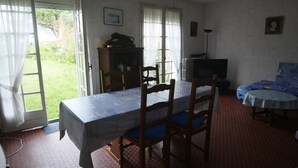 Un comedor con una mesa, sillas, un televisor y un sofá.