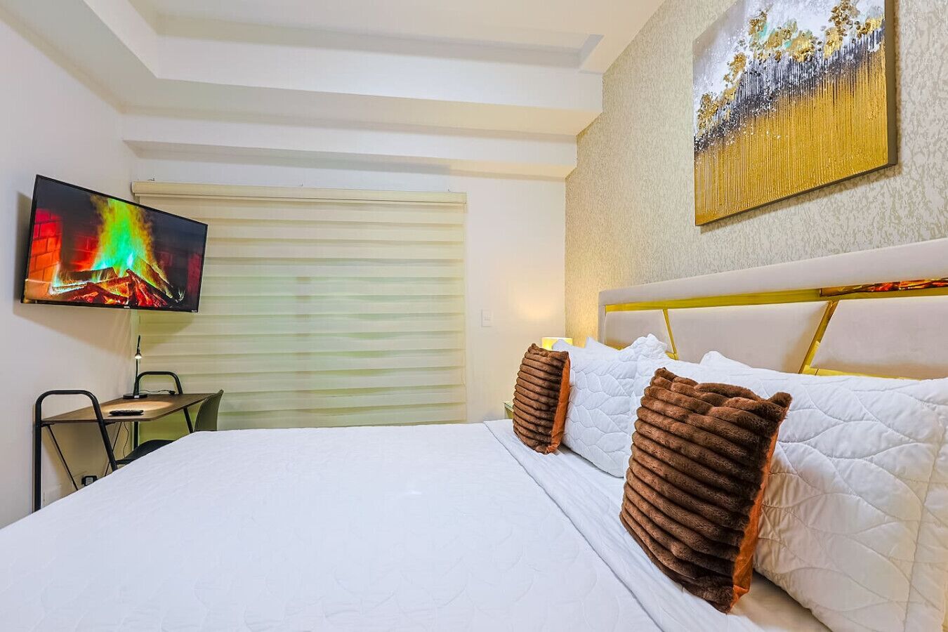 Une chambre d’hôtel avec un lit, une télévision, un bureau et une chaise.