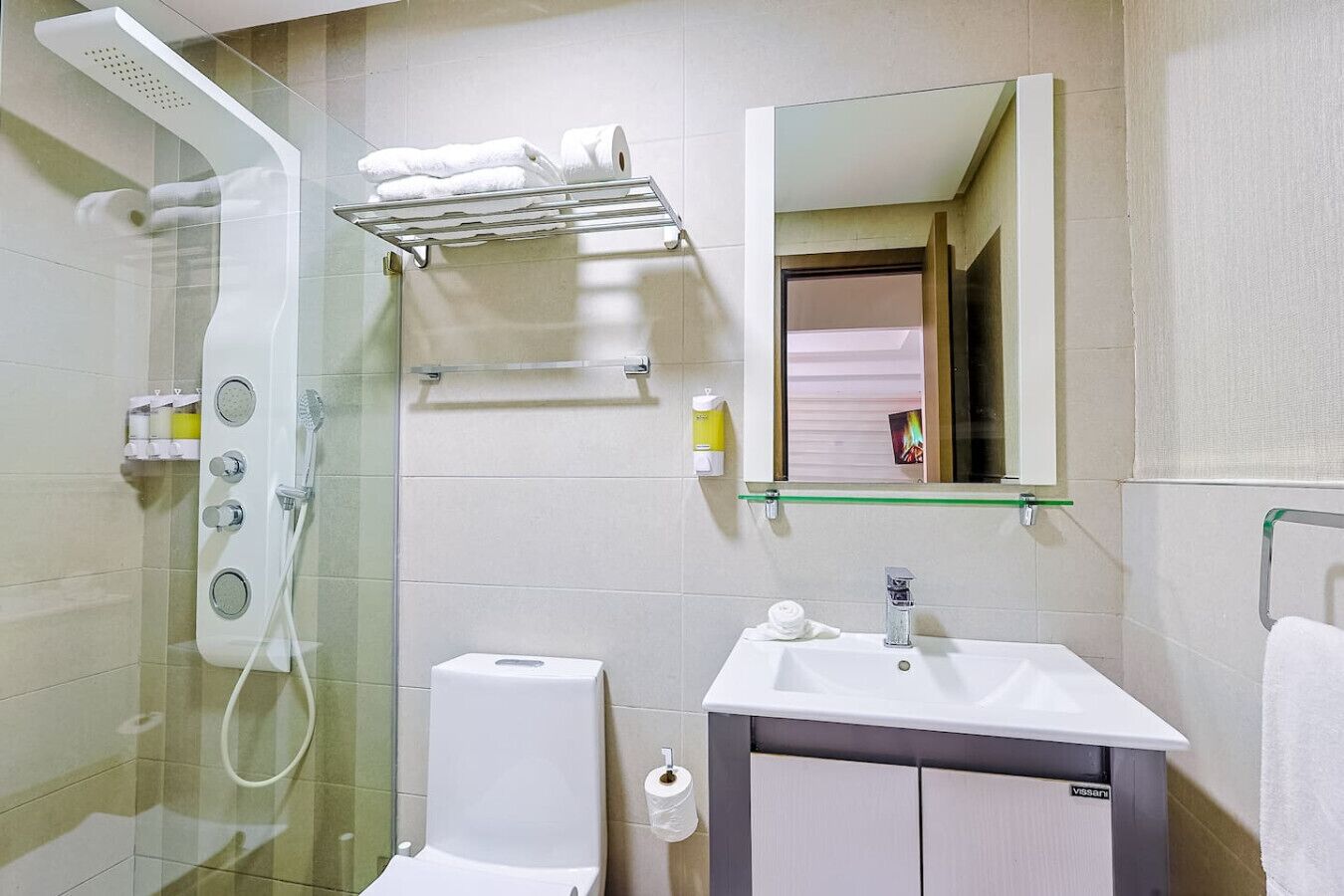 A modern bathroom with a glass-enclosed shower, a white sink, and a mirror above it.