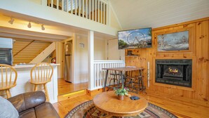 Un salon chaleureux avec une cheminée, des meubles en bois et un coin repas.