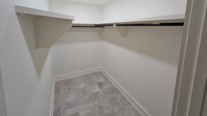 A small, white-walled room with a sloped ceiling, recessed lighting, and a tiled floor. - New build 1 bed apartment with full size bathroom and kitchen. (Denham Springs)