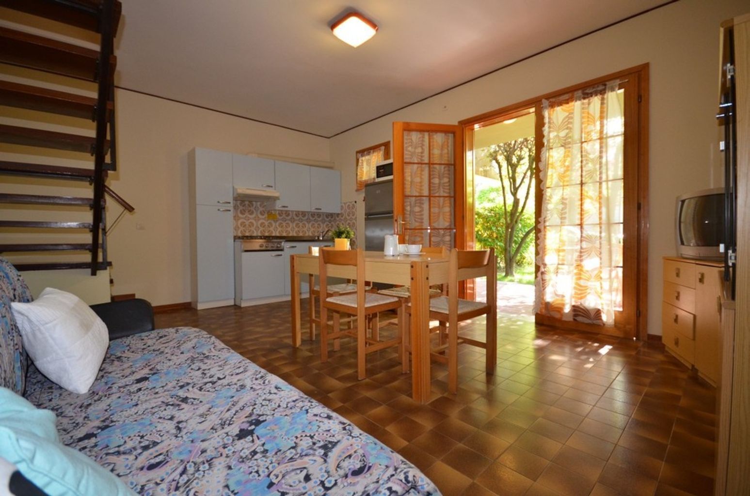 A compact living space with a dining area, kitchenette, and a sofa.